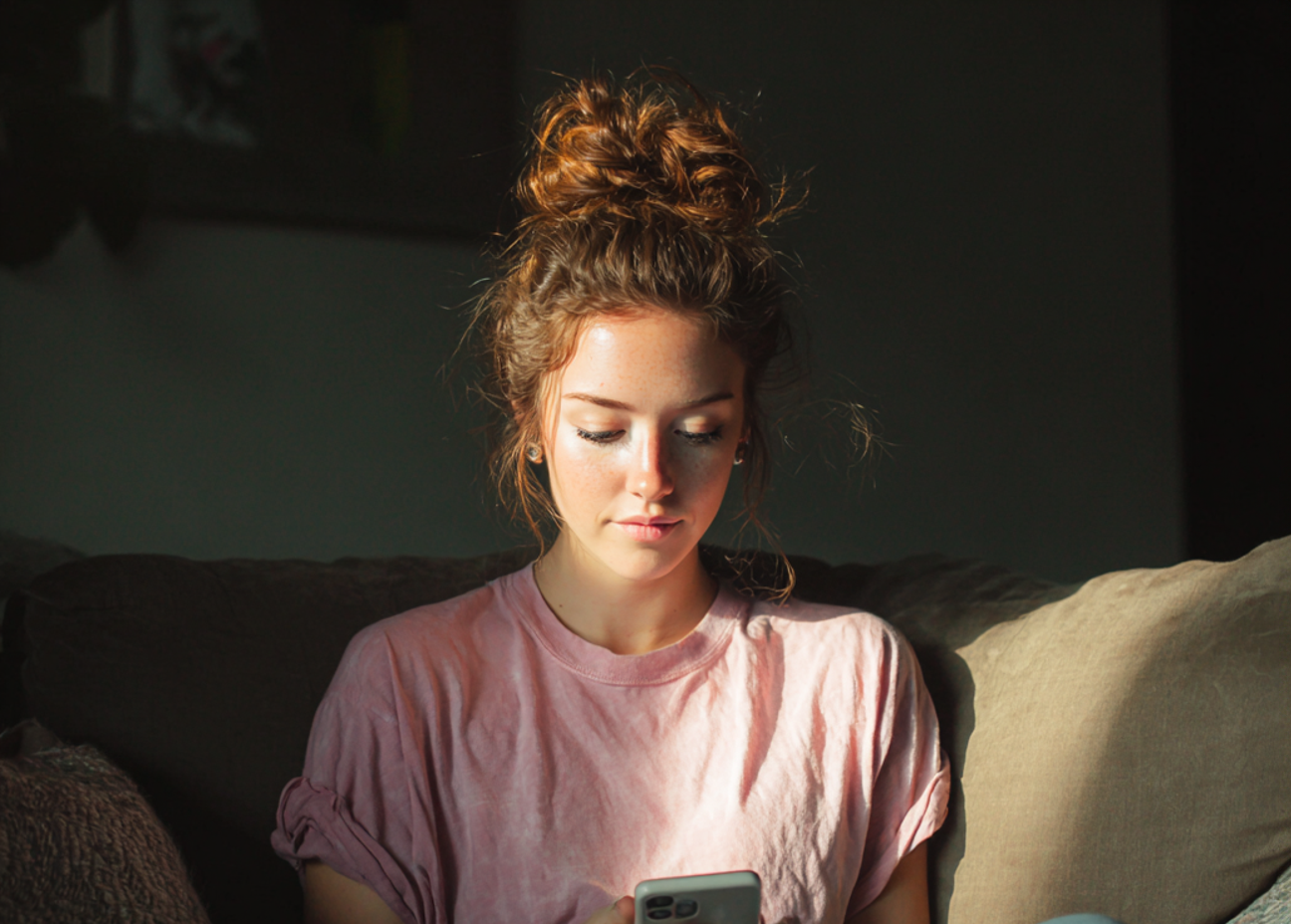 A woman sitting on a couch and using her phone | Source: Midjourney