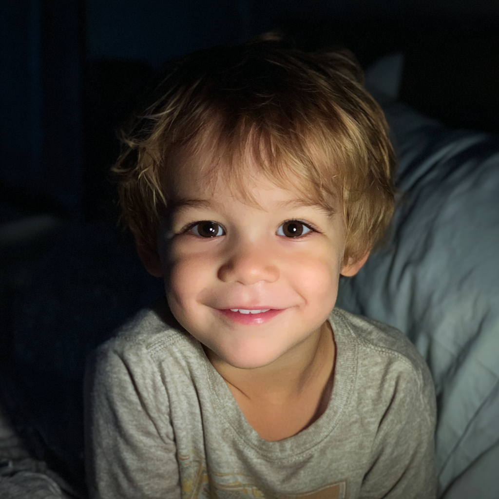 A smiling little boy sitting in his bed | Source: Midjourney